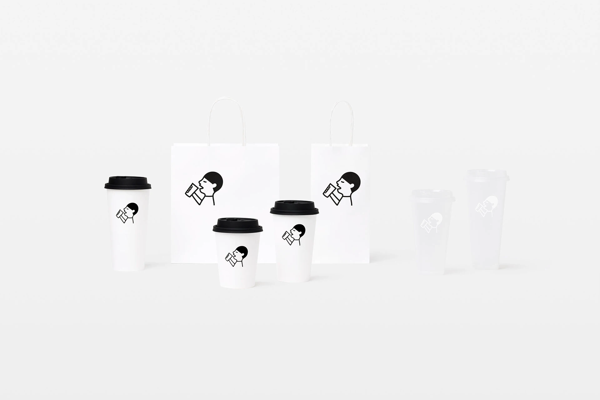 Símbolo HEYTEA aplicado a vasos y bolsas blancas de diferentes tamaños