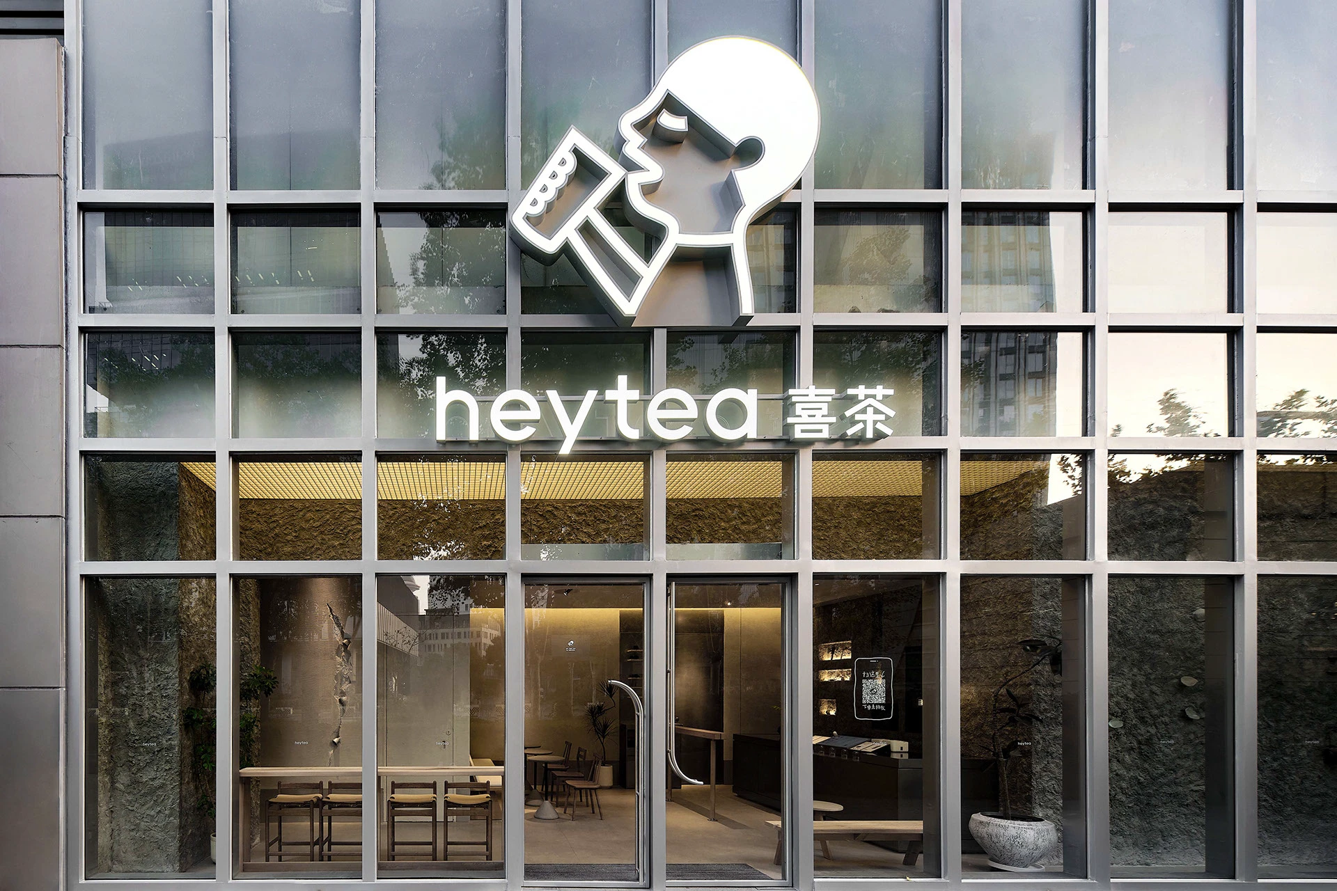 Símbolo de HEYTEA y nombre de la marca aplicados a una fachada