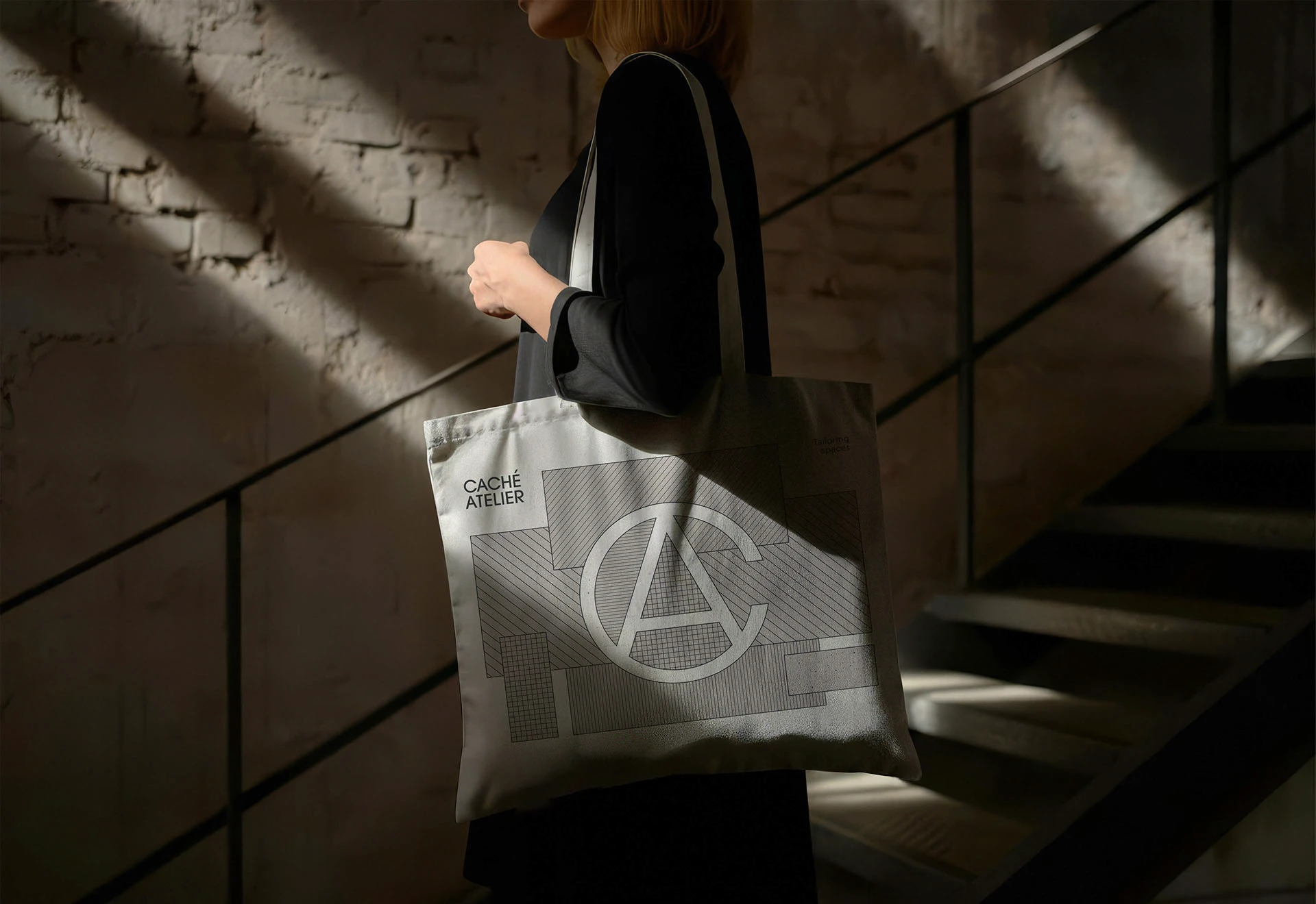 Bolsa de Caché Atelier con monograma y líneas aplicada en un espacio arquitectónico
