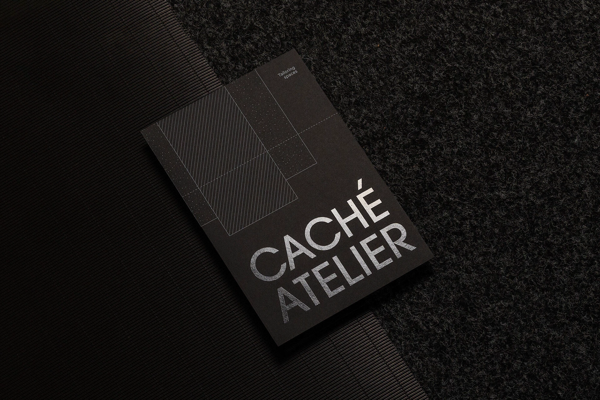 Tarjeta oscura de Caché Atelier con nombre y trama de líneas