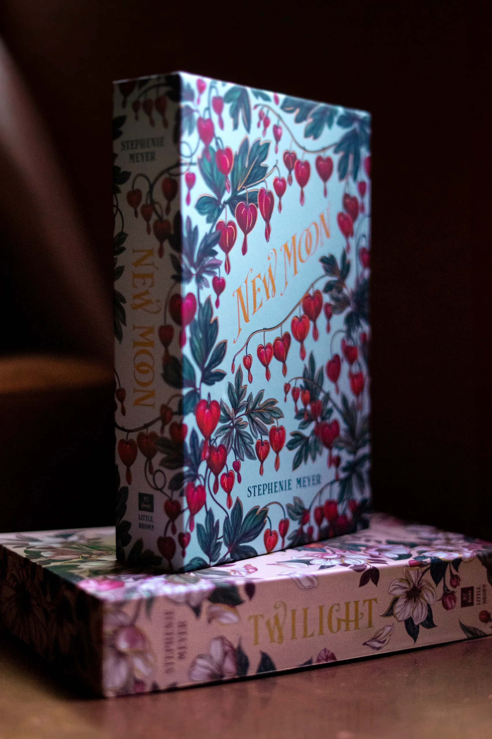 Estuche ilustrado de New Moon con flores y lettering dorado